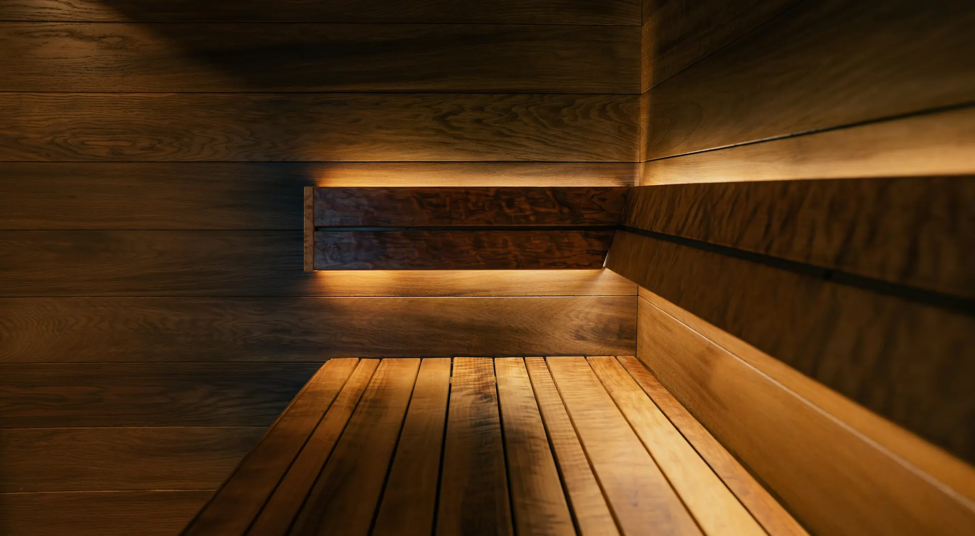 Dim wooden sauna corner with a slatted bench lit by a warm glow